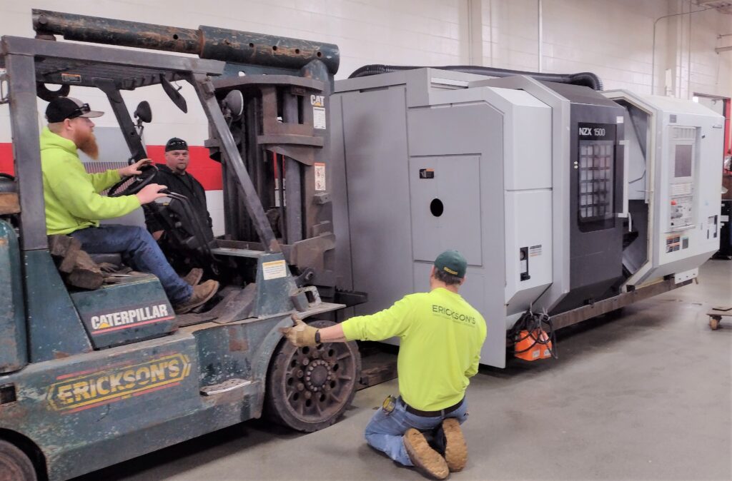 The crew from Erickson's Crane mounts the Mori Seiki on rollers and prepares to carefully move the large machine through the shop floor.